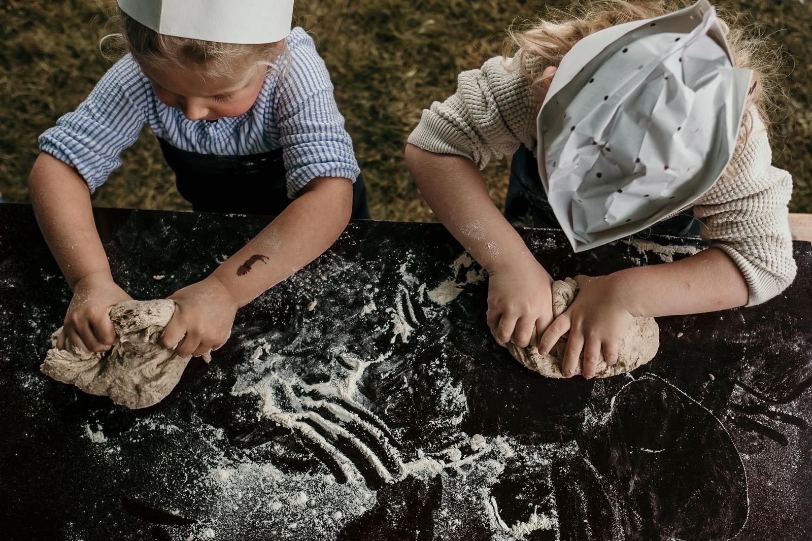 2 Kinder von oben die Teig auf einer mehligen Arbeitsfläche kneten