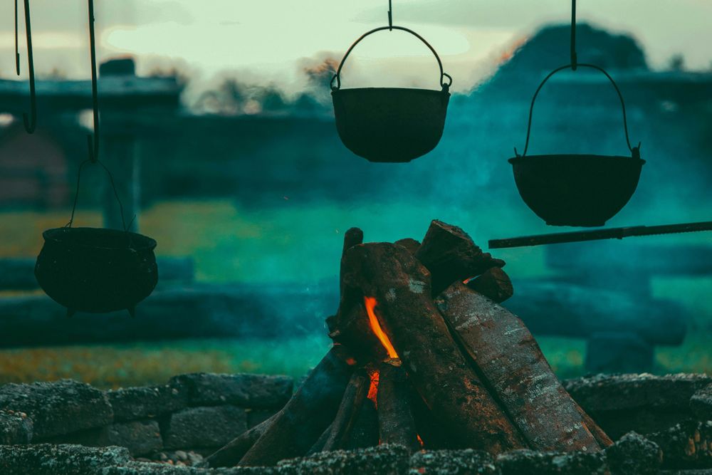 3 Kessel über einem Lagerfeuer